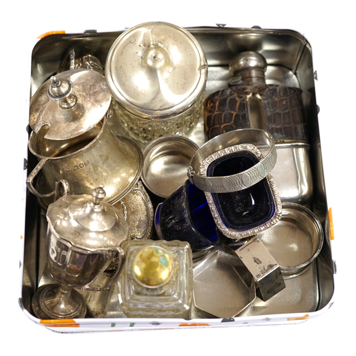 A collection of small silver collectables including a mounted hip flask, five napkin rings, two mounted toilet jars, trinket box, two wine labels, three condiments, a silver collar and a small trophy cup. Condition - poo